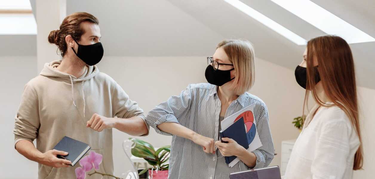 Employees wearing face masks encouraging each other