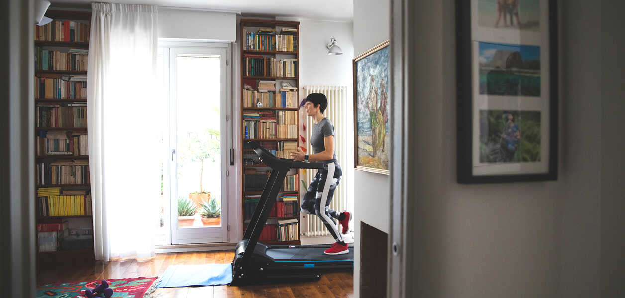 Man running on a treadmill in his library