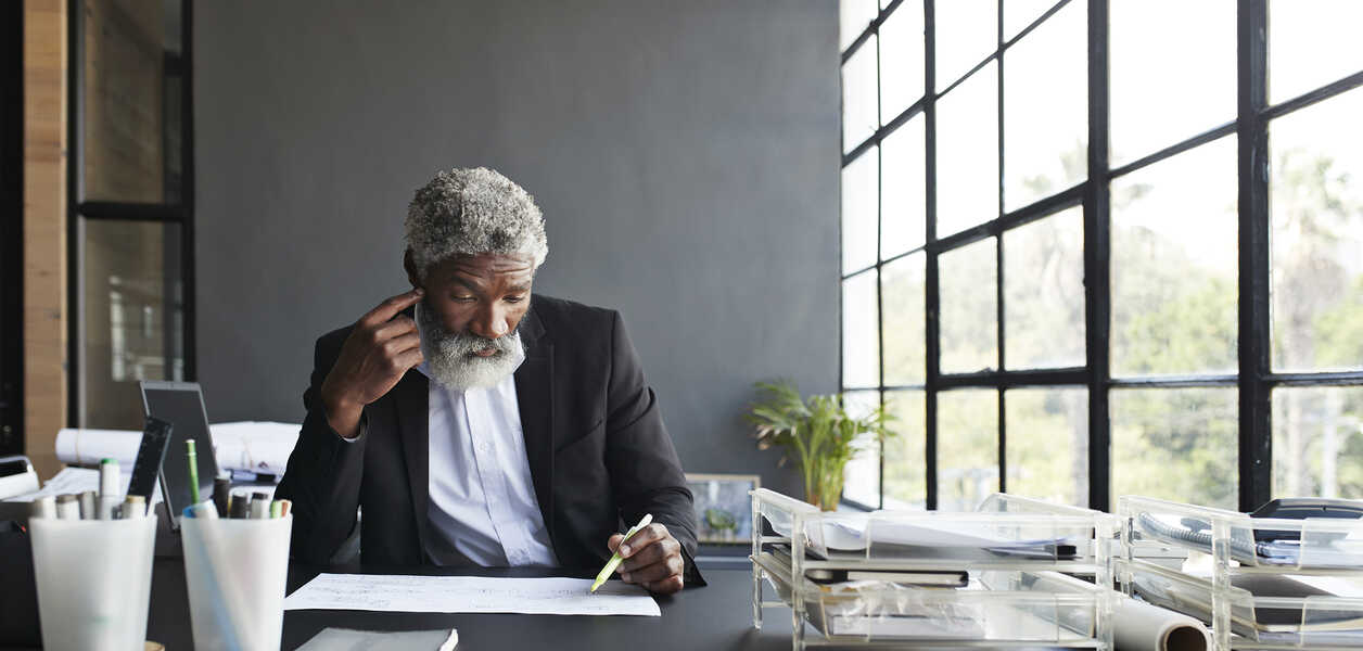 Man reading papers while sitting at his desk