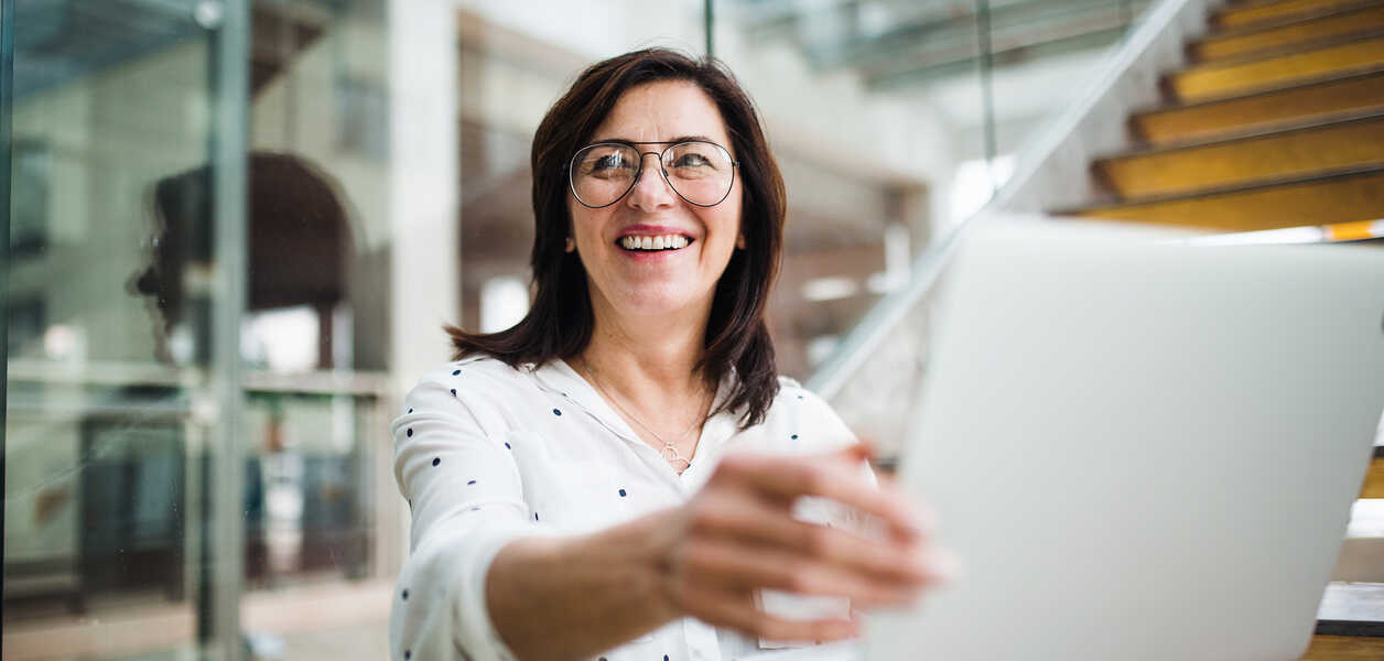 Woman smiling while showing her laptop to others