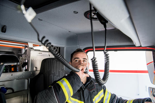 Homme parlant à la radio dans un véhicule d’urgence