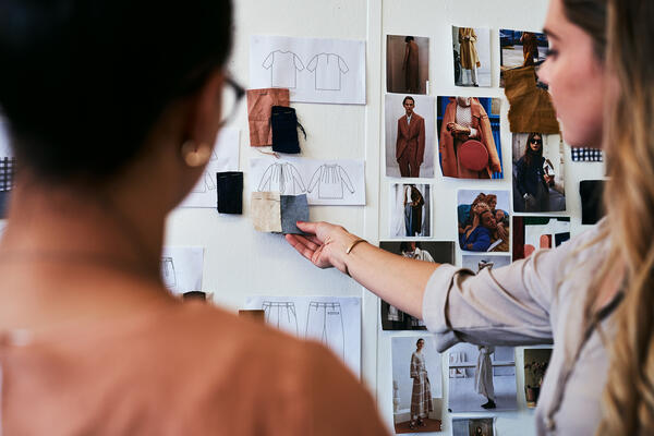Woman showing mood board for fashion editorial to coworker