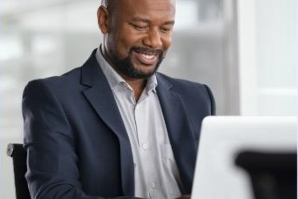 Man smiling while working at his laptop