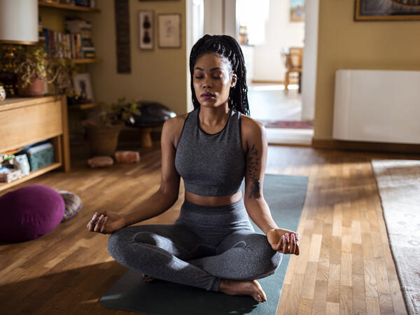 Femme pratiquant le yoga dans son salon