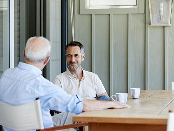 Deux hommes discutant en prenant un café