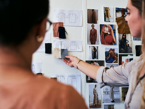 Woman showing mood board for fashion editorial to coworker