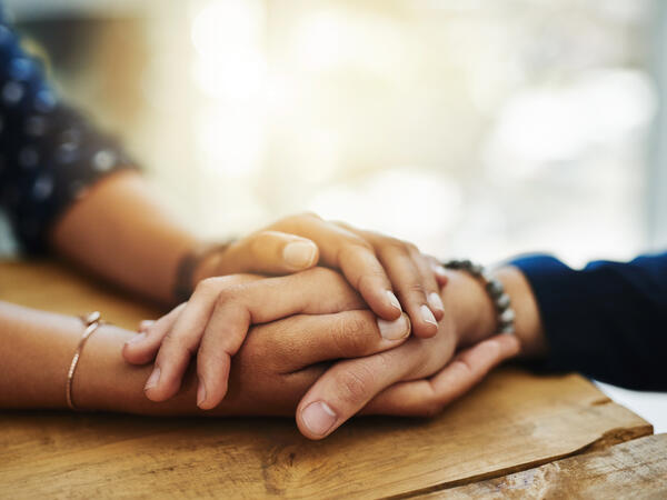 Couple holding hands while resting them on a table