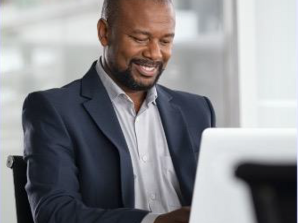Man smiling while working at his laptop