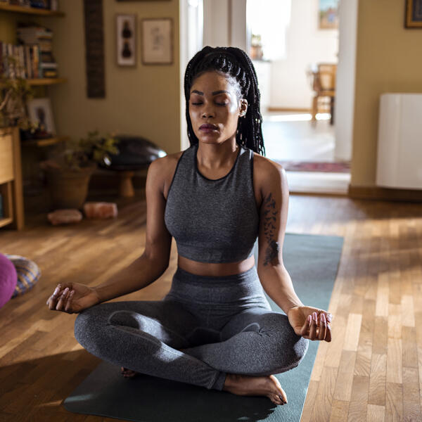 Femme pratiquant le yoga dans son salon